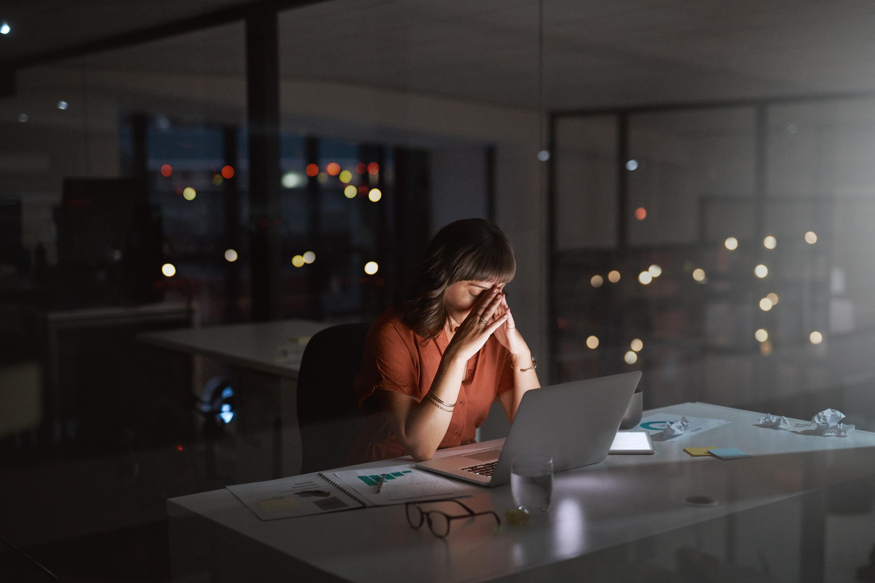 Women in office at desk late night.